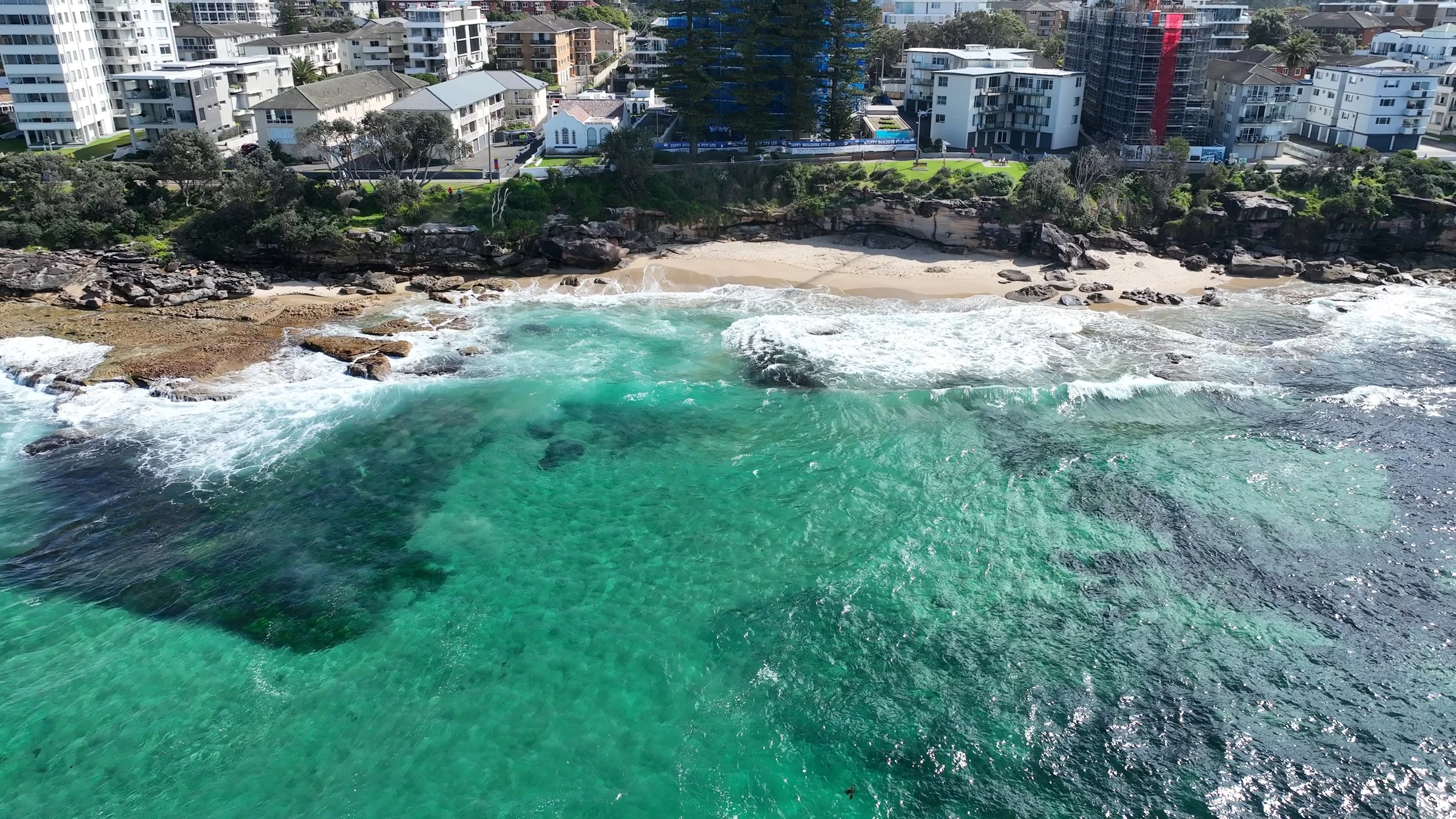 Aerial view of Blackwoods Beach beneath the cliffs with turquoise water and breaking waves