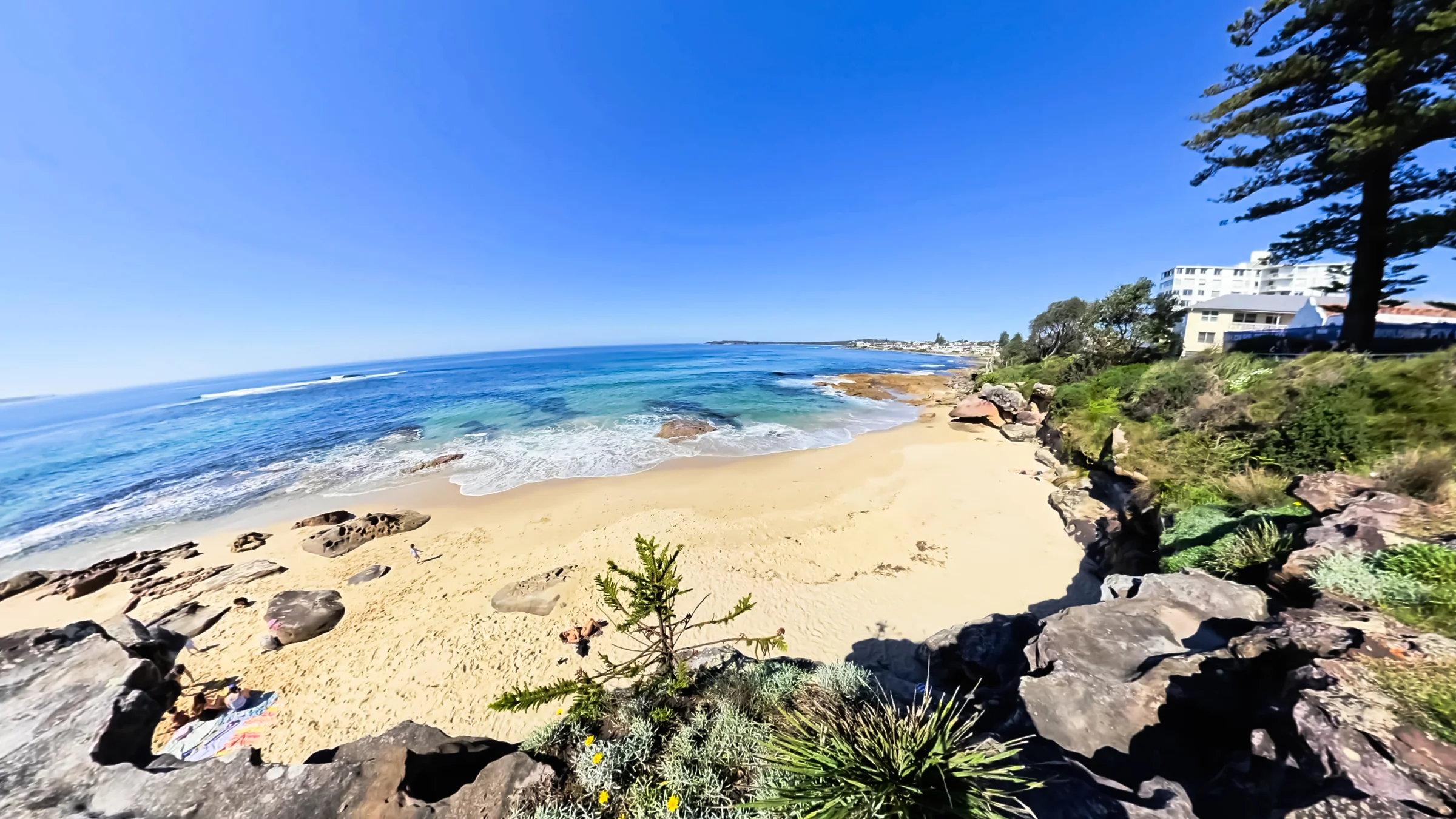 View down to the sand and rocky shoreline of Blackwoods Beach from the coastal path