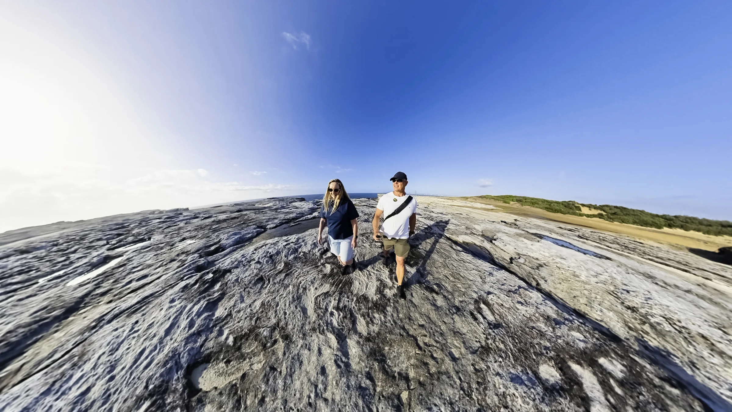 Rob and Sue on broad sandstone with the ocean beside them