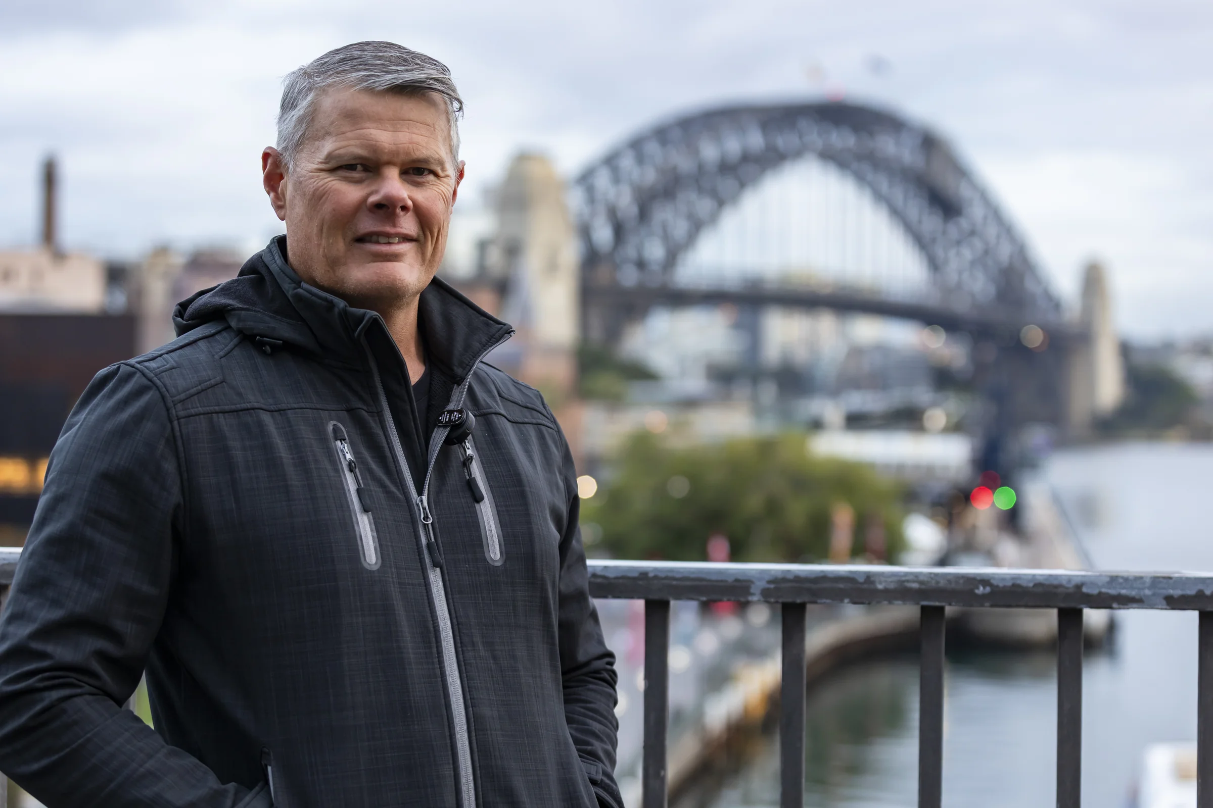 Rob beside the Cahill Walk railing with the Harbour Bridge behind him