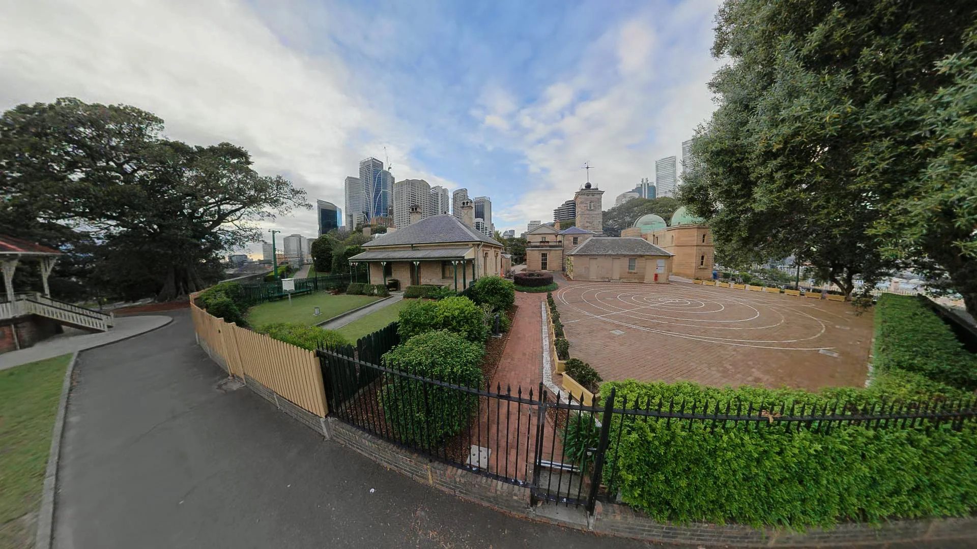 Path and lawns beside Sydney Observatory with city buildings beyond