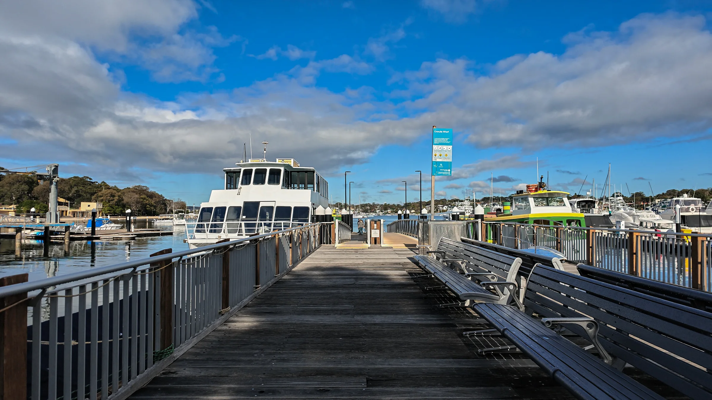 The timber boardwalk at Cronulla Wharf with boats alongside