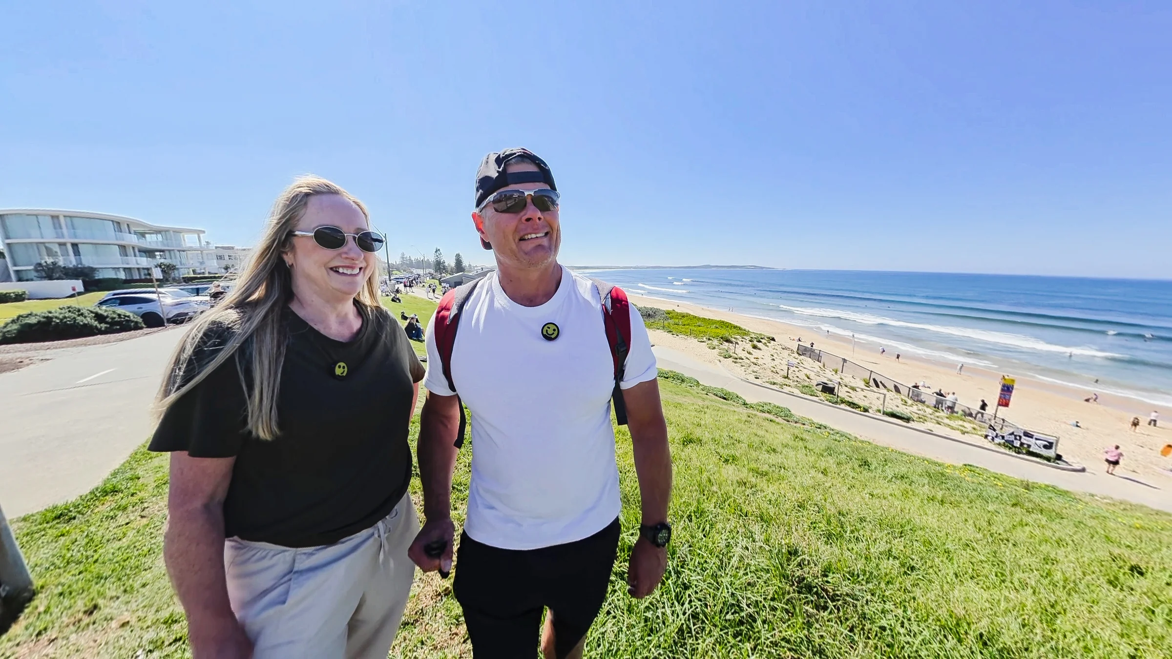 Rob and Sue standing on the grassy hill above Elouera Beach