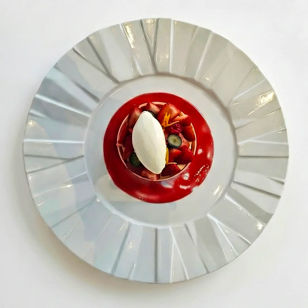 Red berry dessert on a white plate