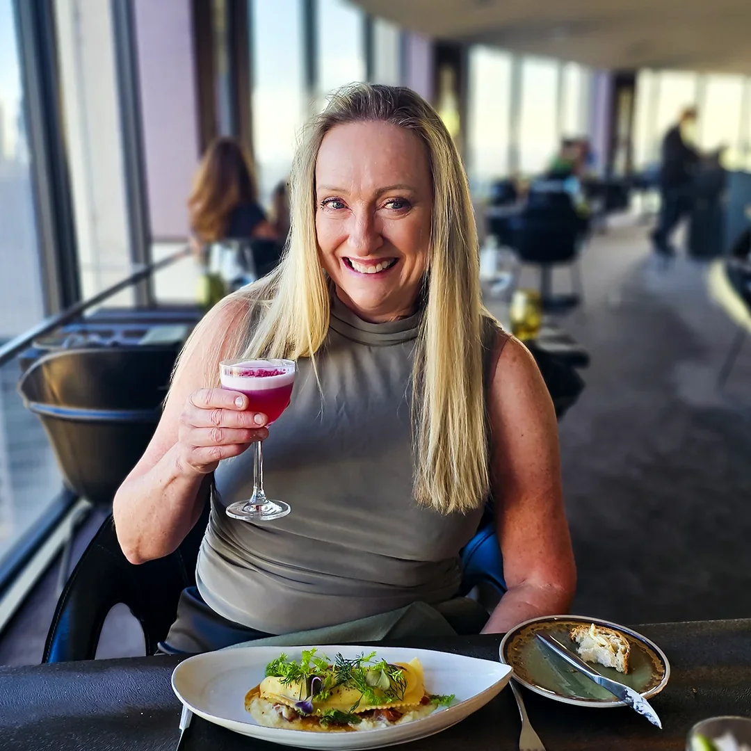 Sue enjoying a meal and a drink at a restaurant