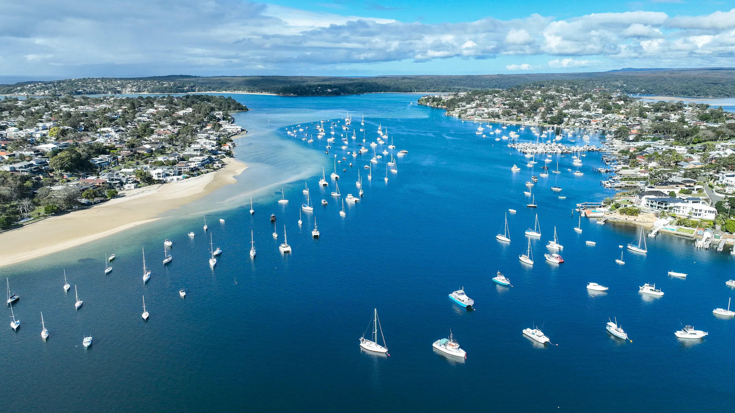 Aerial view of Gunnamatta Bay, with boats moored between sandy shores and tree-lined neighbourhoods