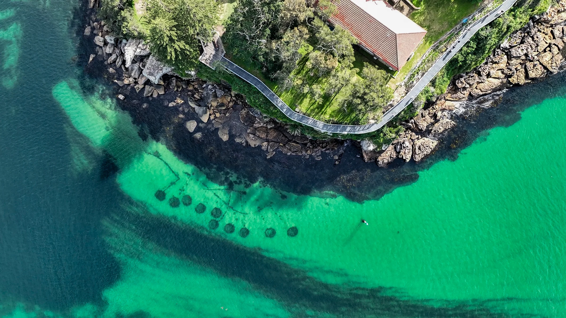 Aerial view of turquoise water beside the Hungry Point shoreline