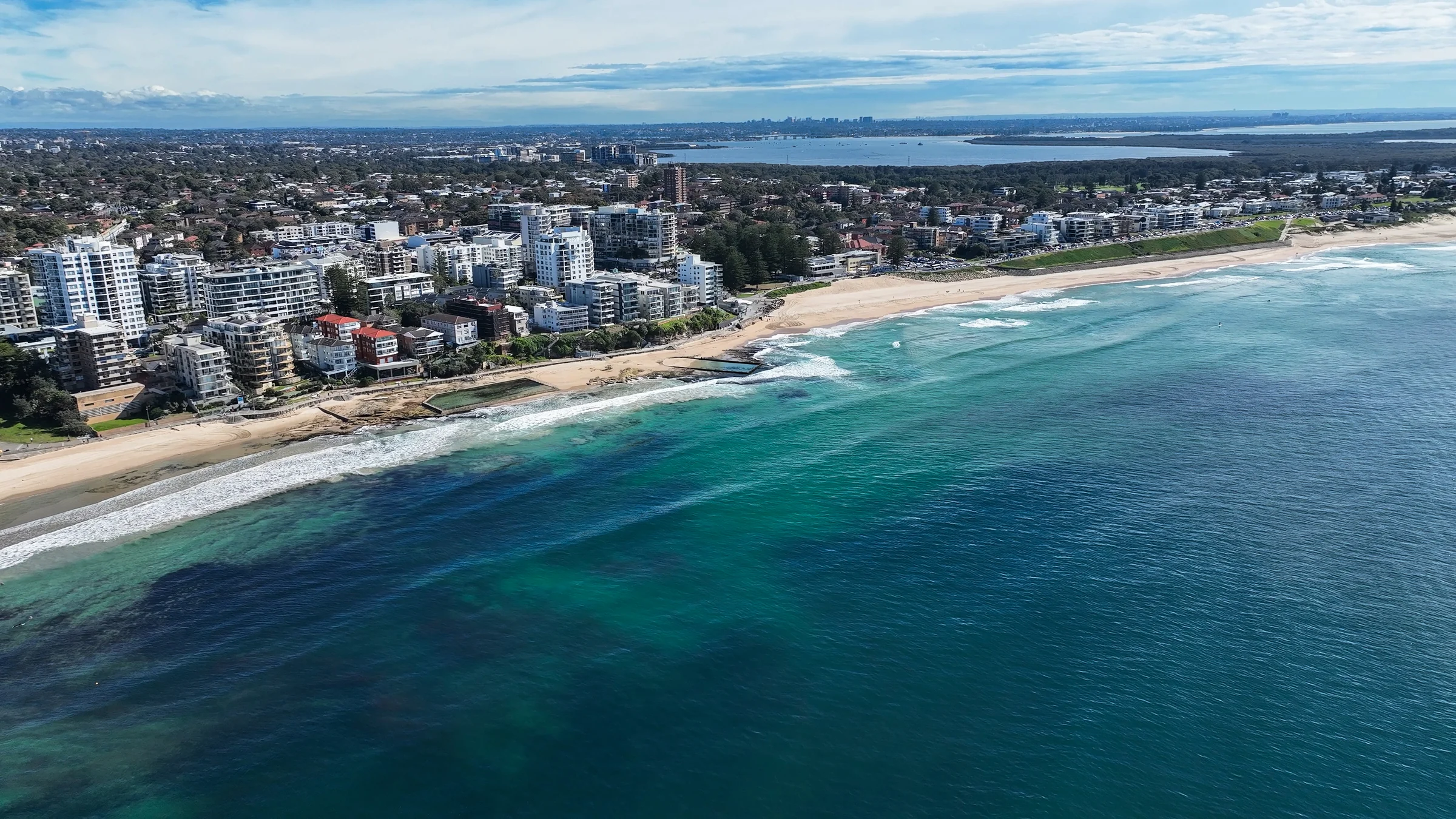 Aerial view of North Cronulla Beach, the beachfront park and coastline stretching north