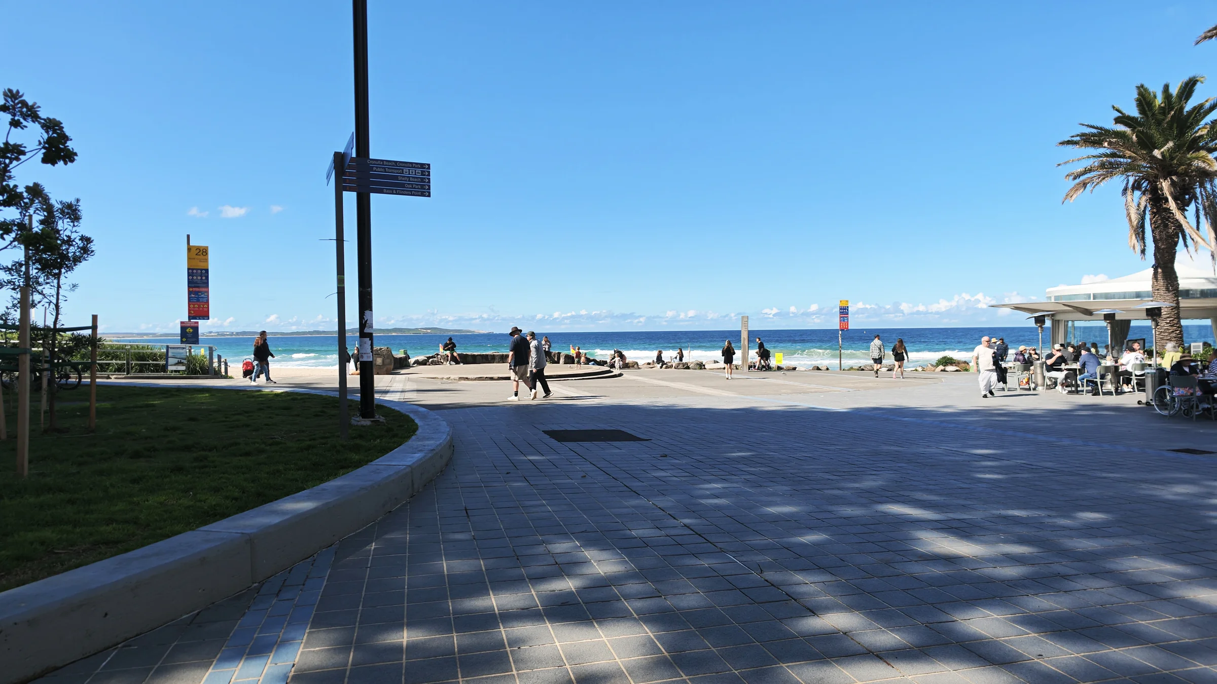 Wide paved promenade beside Dunningham Park leading to North Cronulla Beach and cafés