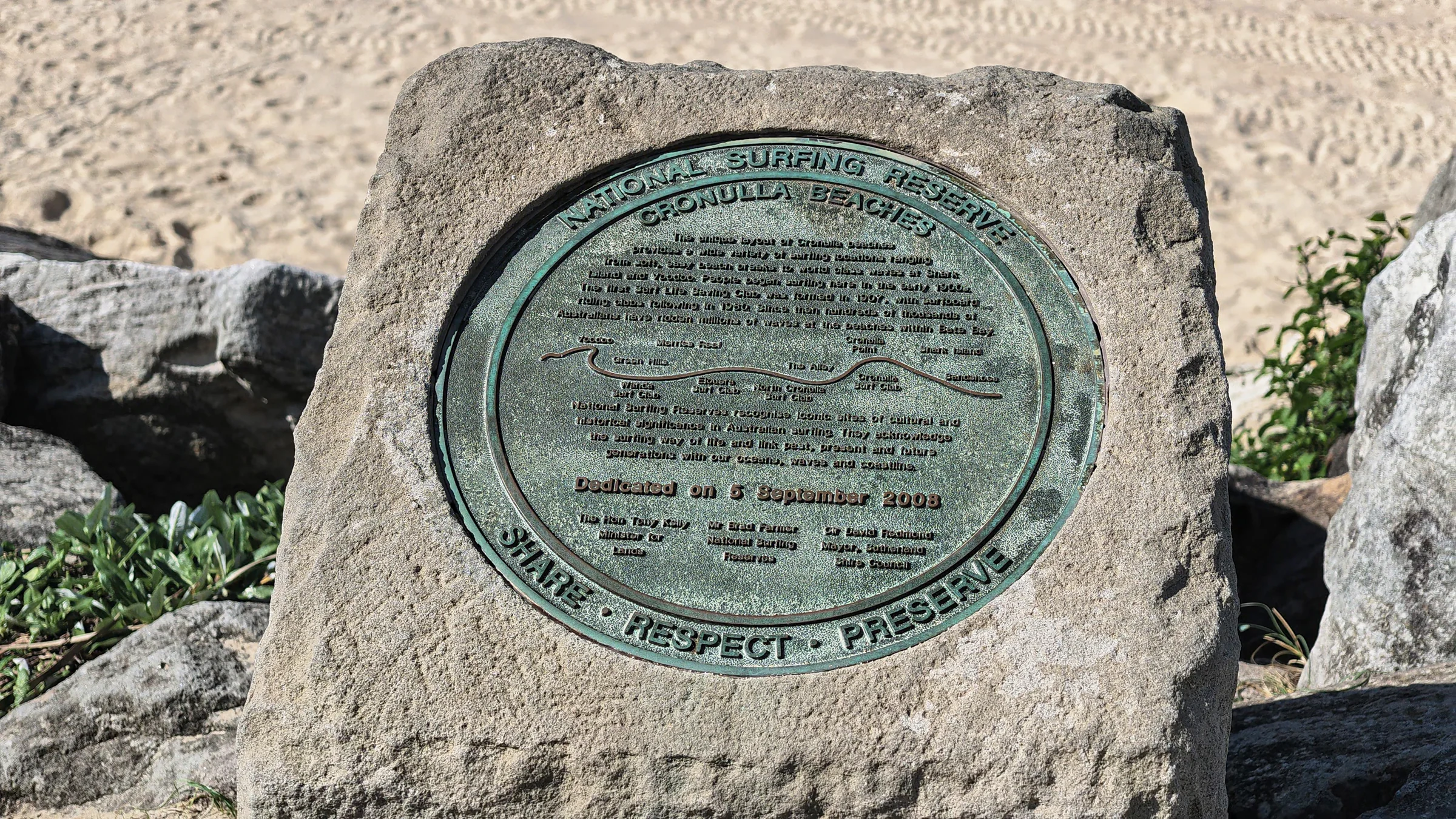 National Surfing Reserve plaque on a rock beside the sand at Cronulla