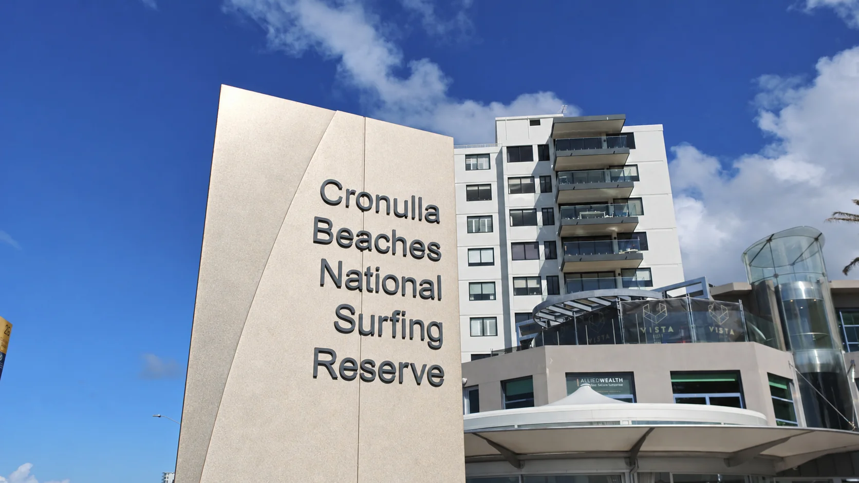 Restored Cronulla Beaches National Surfing Reserve sign beside the beachfront buildings
