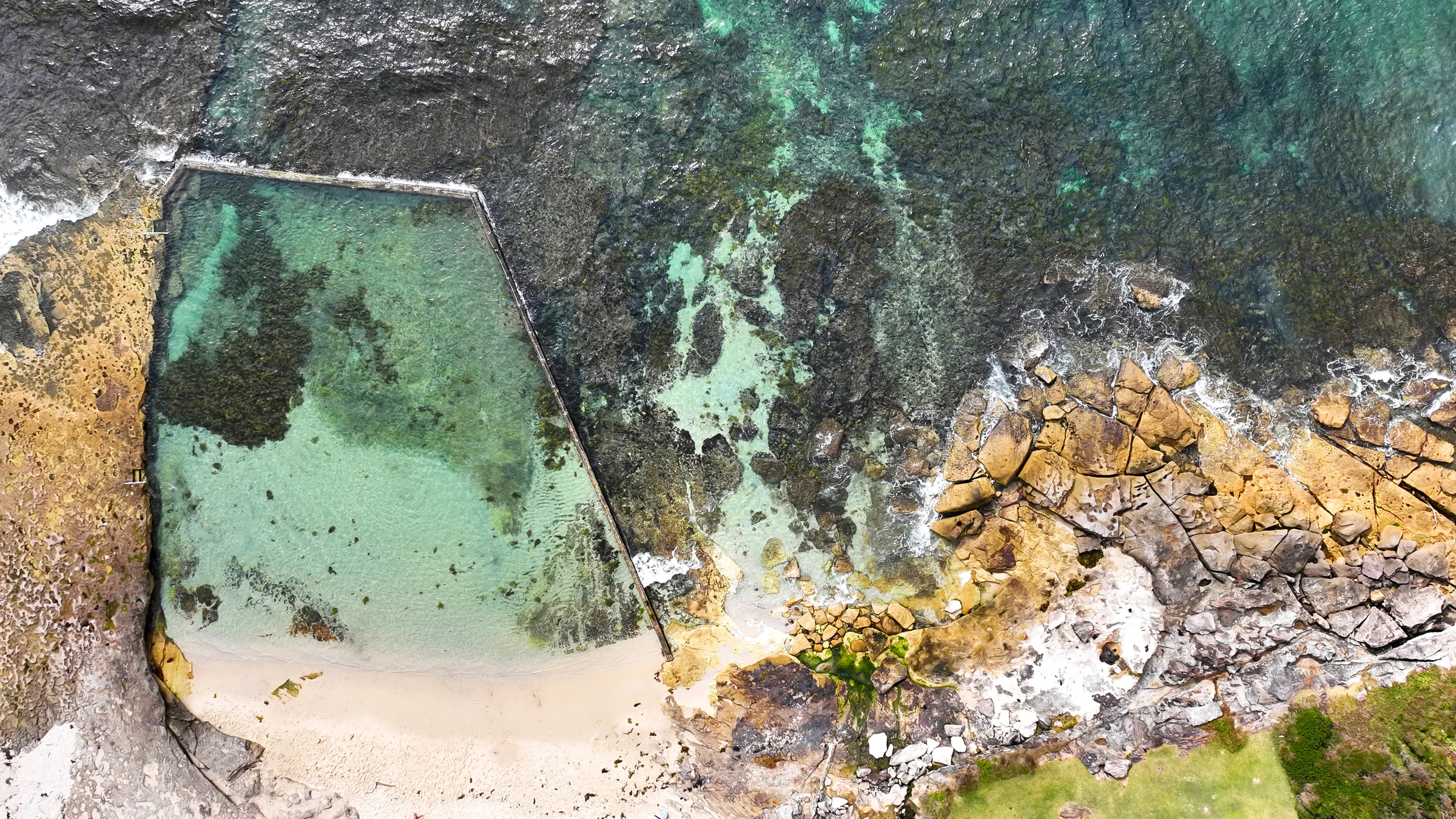 Overhead view of Oak Park ocean pool, its beach and surrounding reef