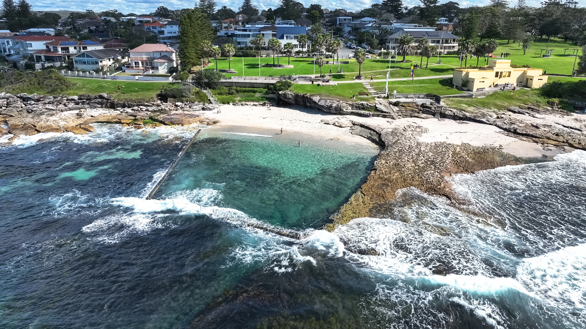 Oak Park ocean pool with the sandy beach and grassy park behind it