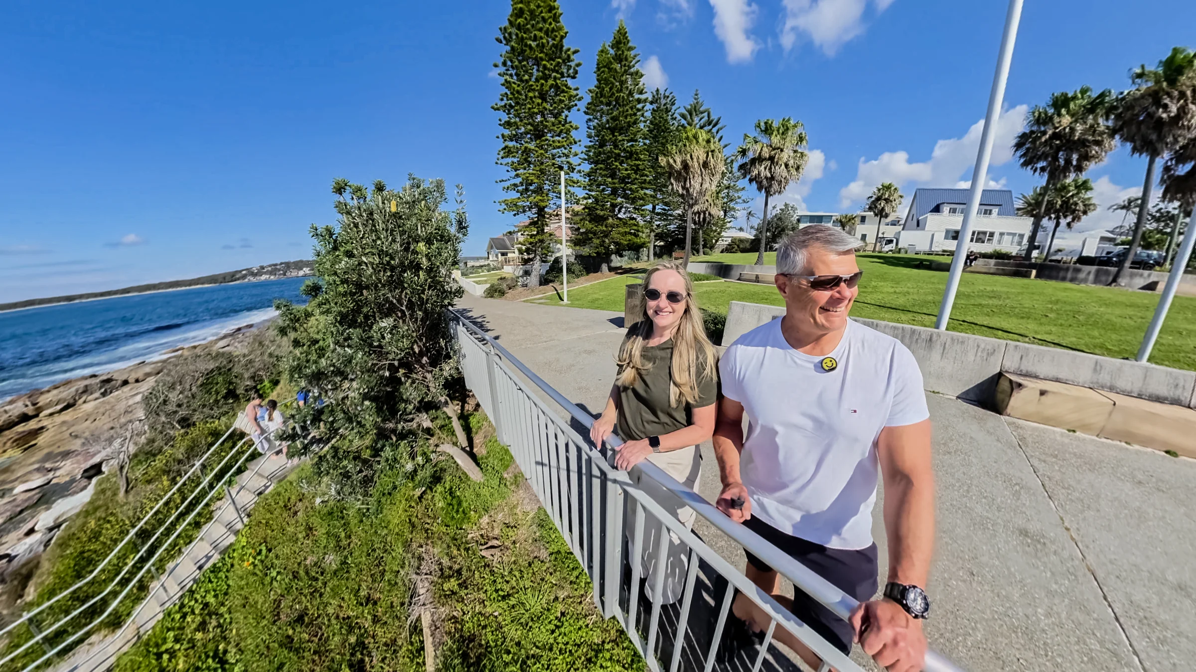 Rob and Sue smiling beside the stairs and ocean at Oak Park