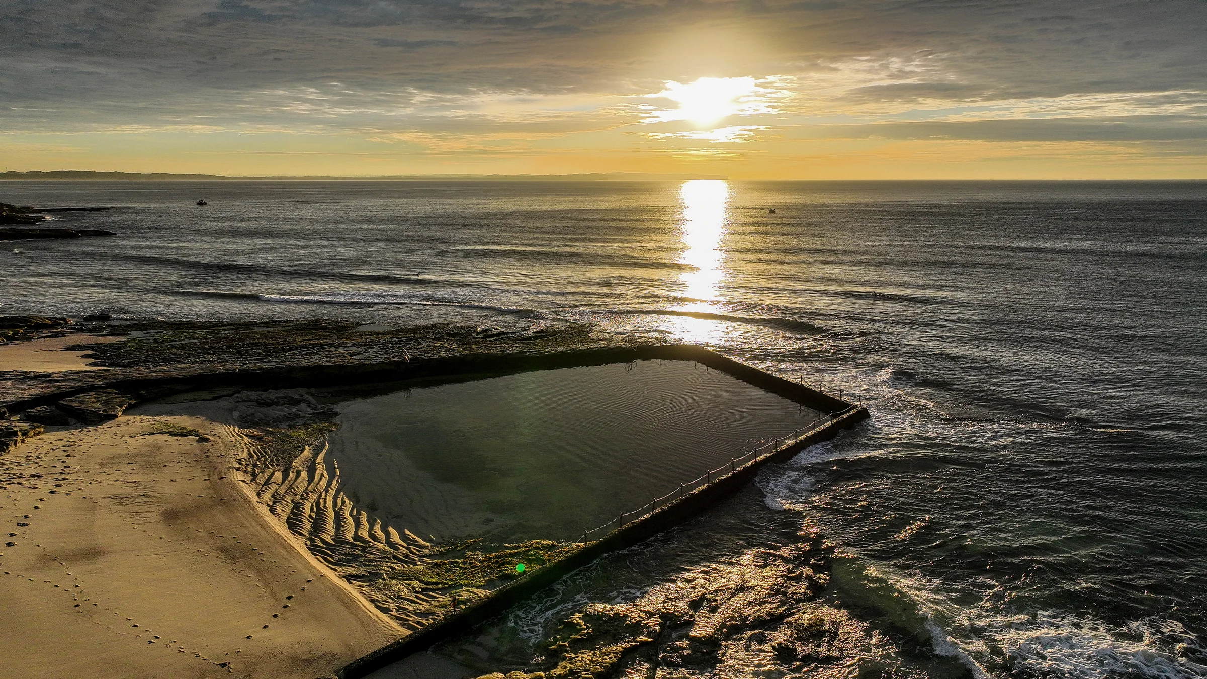 The sun rising over the ocean behind Oak Park pool