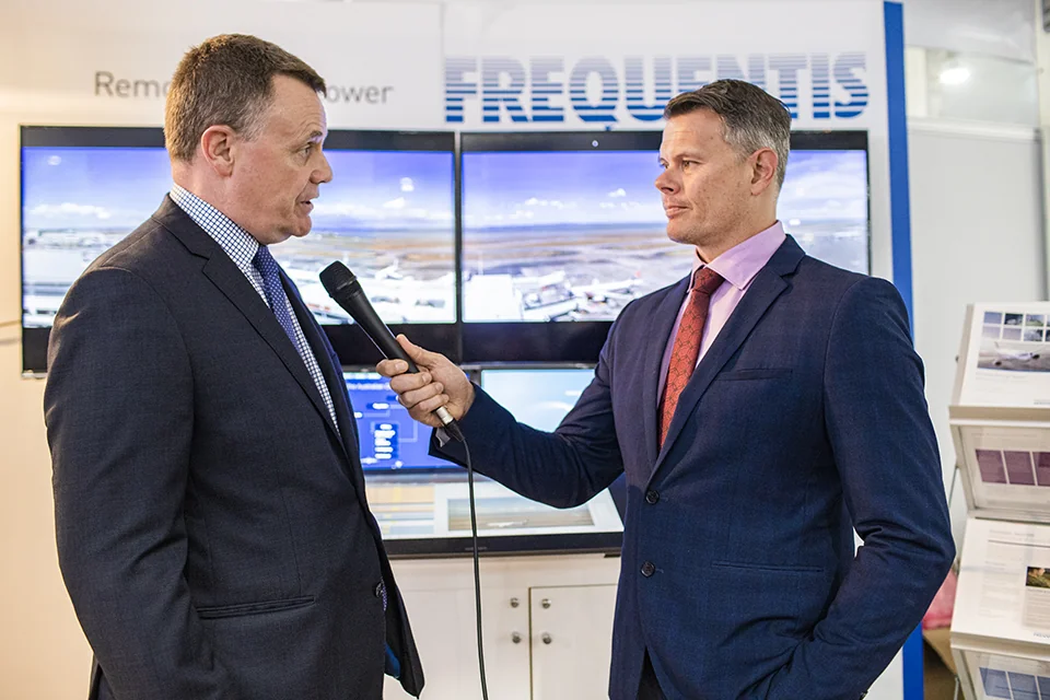 Rob holding a microphone while interviewing a guest at a business event