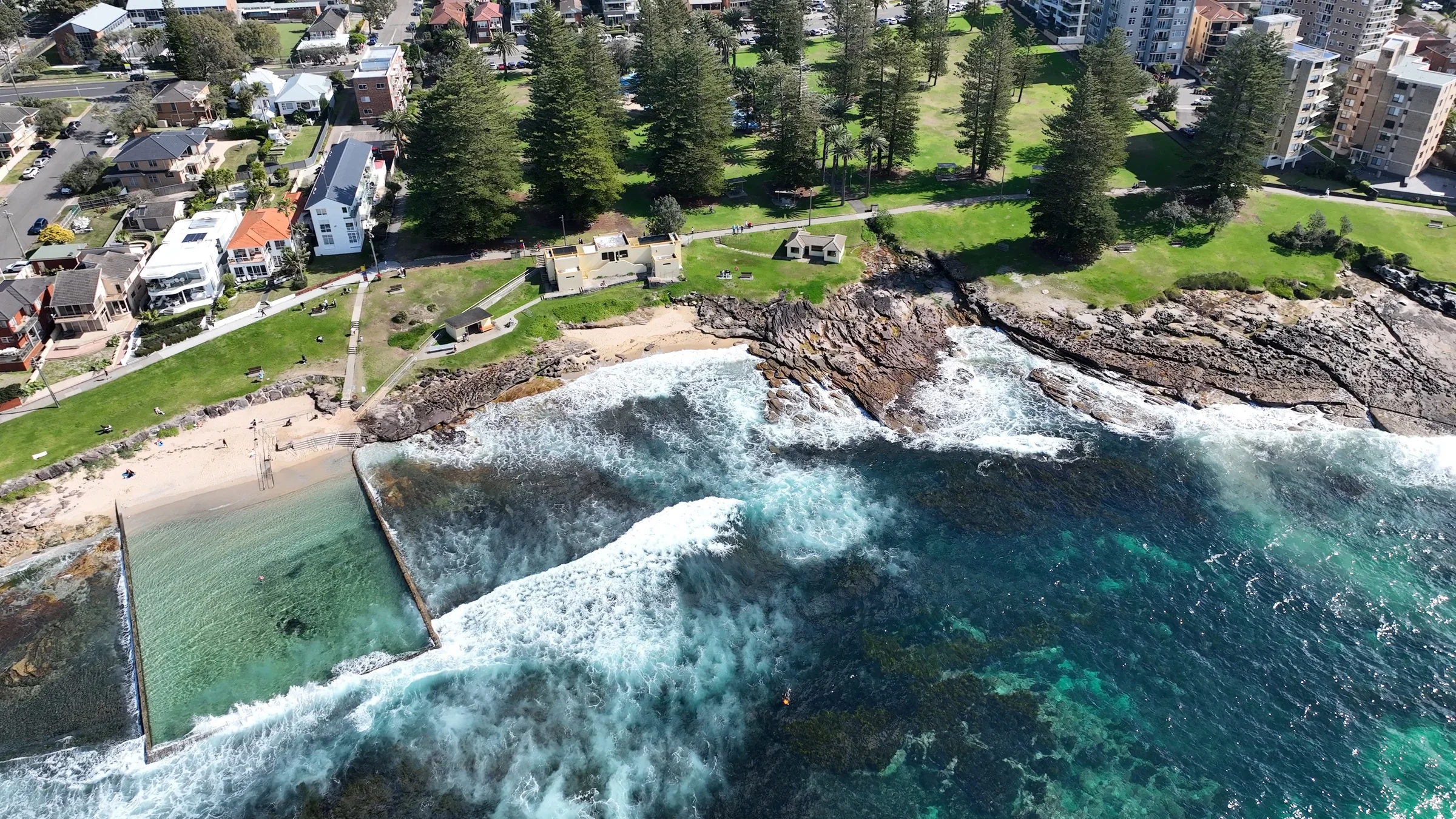 Shelly Beach ocean pool beside waves washing over the surrounding rock platform