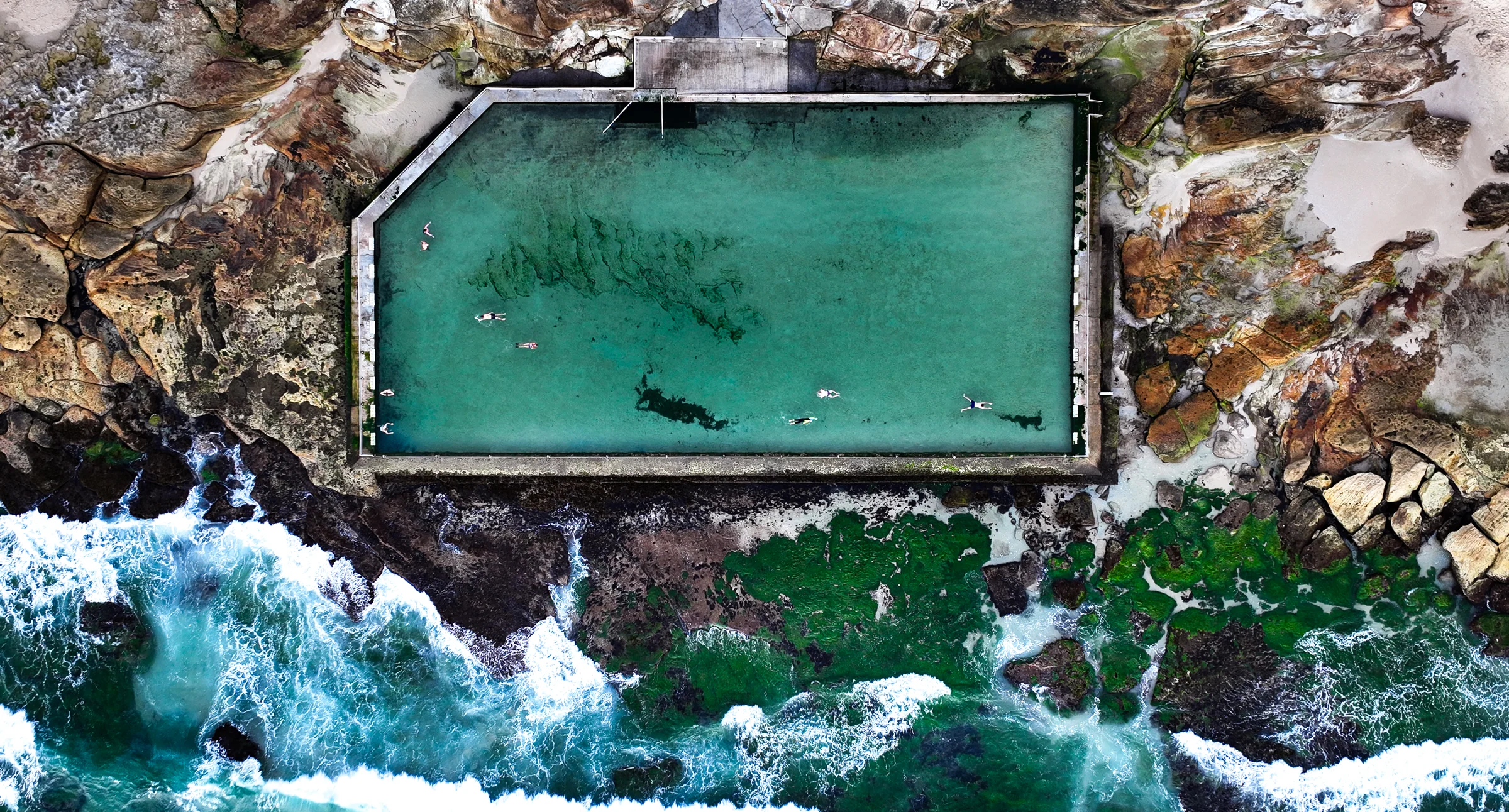 Swimmers in the larger Cronulla ocean pool viewed directly from above