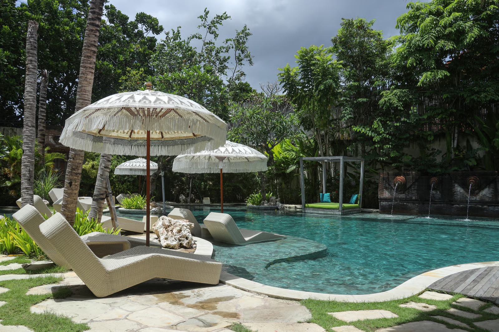 A tropical resort swimming pool with Balinese-style umbrellas